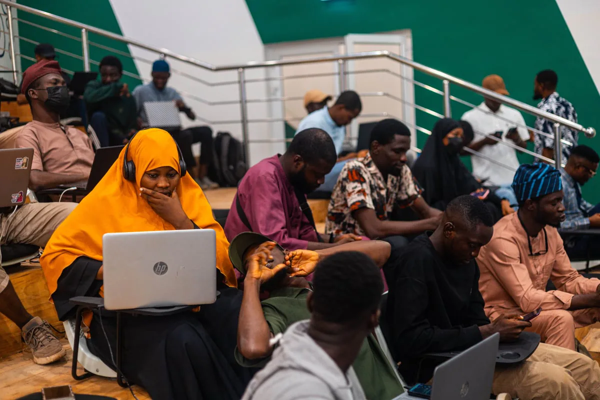 Builders working on laptops during a community session in Benin City.